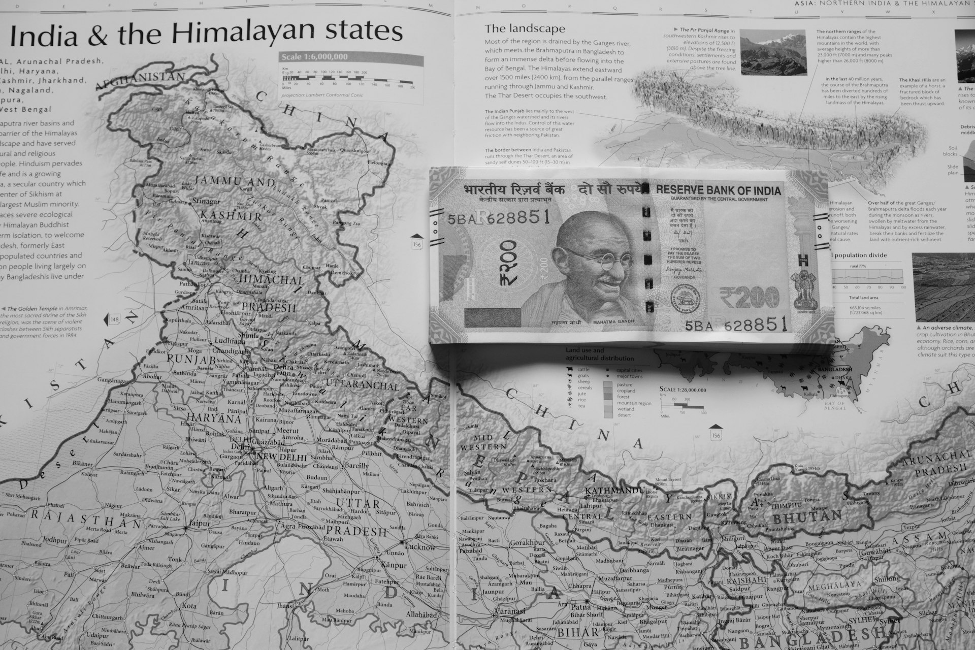 Indian currency rests on a map of india.